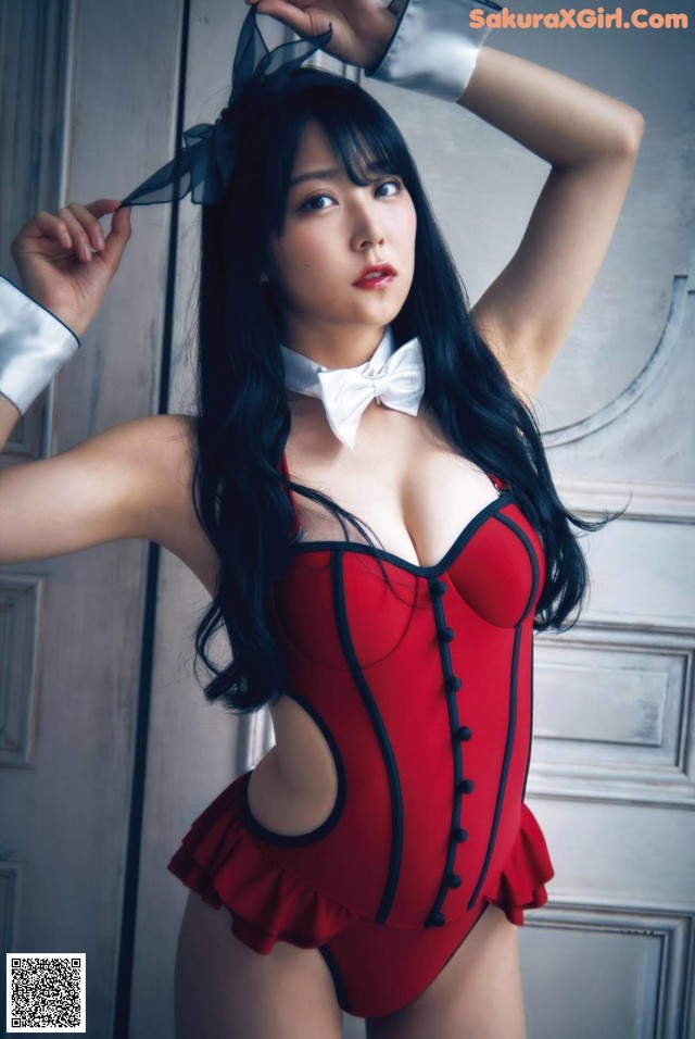 A woman in a red corset posing for a picture.