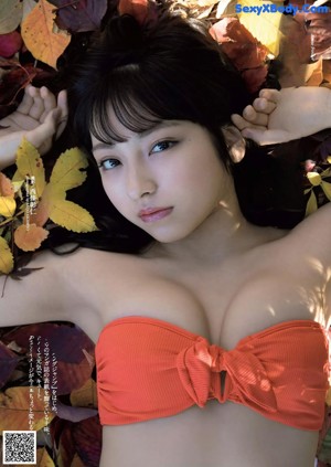 A woman in a red bathing suit is posing in a pool.