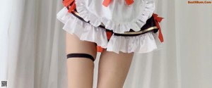 A woman dressed in a maid outfit holding a tray.