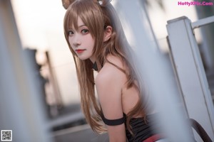 A woman in a cat costume sitting on a wooden dock.