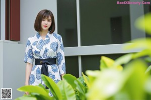 A woman standing in front of a sliding glass door.