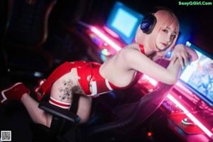 A woman in a red and white outfit standing in front of a computer.