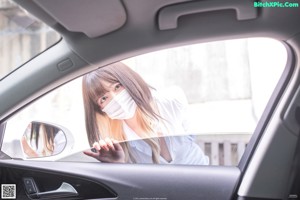 A woman in a black lingerie sitting in a car.