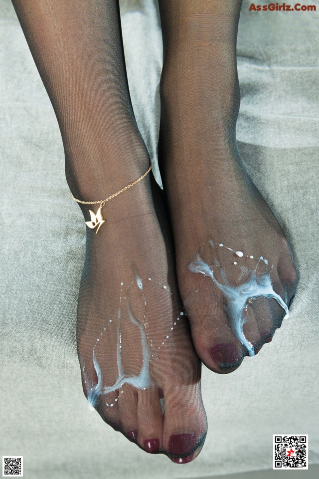 A pair of feet with a gold anklet on them.