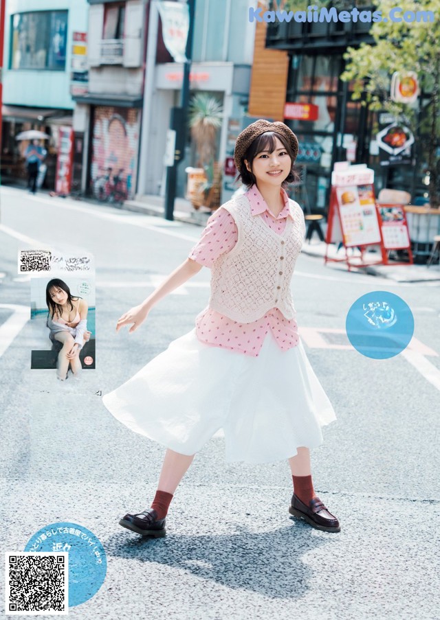 A woman in a white skirt and a pink shirt is walking down the street.