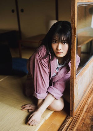 A woman sitting on the floor in front of a window.