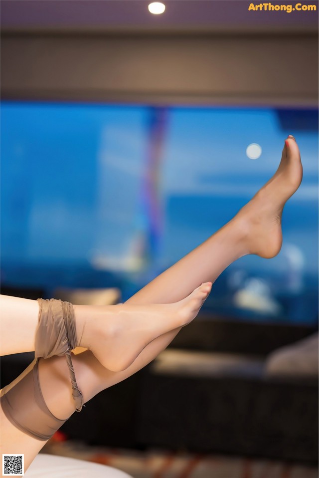 A woman's legs in stockings and stockings on a bed.