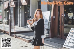 a woman in a black top and red skirt posing for a picture