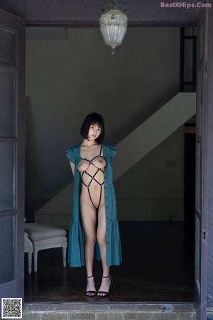 A woman in a black lingerie sitting on a window sill.