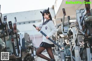 A woman in a school uniform holding a samurai sword.