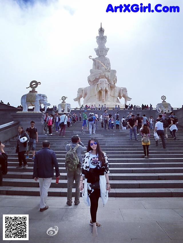 A group of people standing in front of a large statue.