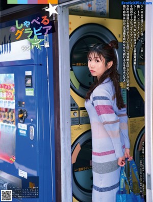 A woman standing in front of a store with her arms crossed.