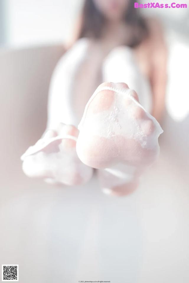 A woman in a white dress is holding a pair of white socks.