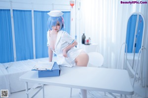 A woman in a nurse outfit is posing on a bed.