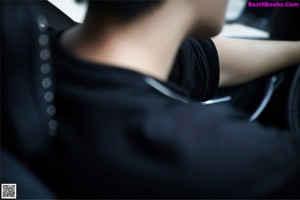 A woman sitting in the back seat of a car.