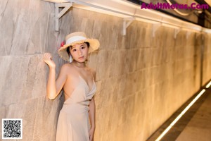 A woman in a straw hat is posing for a picture.