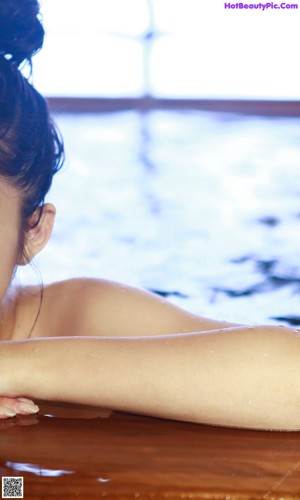 A young woman laying in a pool of water.