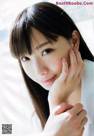 A woman in a white shirt is posing for a magazine.
