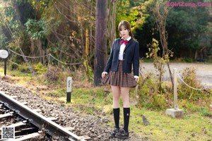 A woman in a school uniform is posing for a picture.