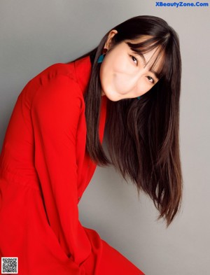 A woman with long black hair wearing a red shirt.