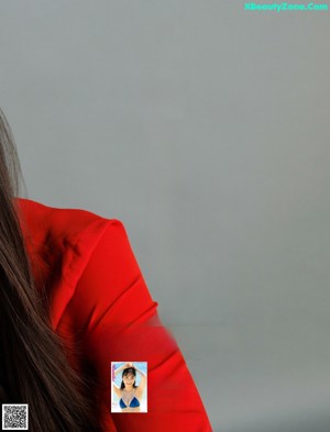 A woman with long black hair wearing a red shirt.