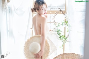 A woman in a straw hat is posing for a picture.