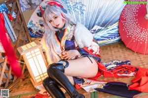 A woman in a kimono sitting on a couch.