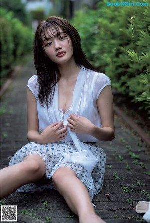 A woman in a white shirt and panties posing for a picture.