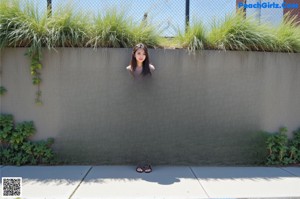 A naked woman standing in a bathtub in a bathroom.