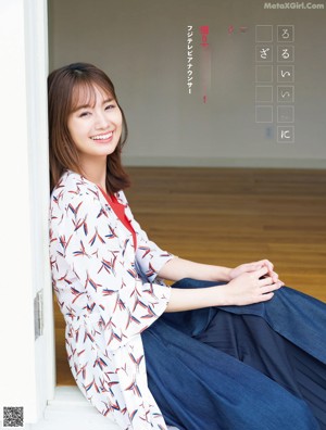 A woman in a white dress standing in front of a window.