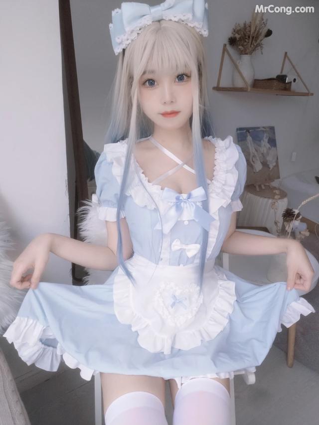 a woman in a blue and white dress sitting on a chair
