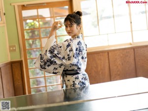 A woman sitting on the floor next to a table tennis racket.