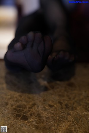 A woman sitting on top of a counter next to a television.
