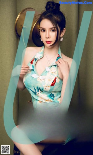A woman in a blue dress sitting on a brown chair.