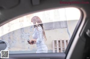 A woman sitting in the back seat of a car.