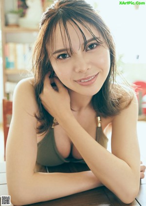 A woman in a bikini sitting on a bed.