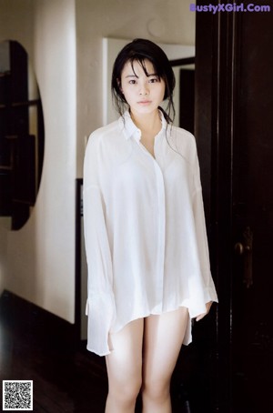 A young woman laying on top of a wooden table.