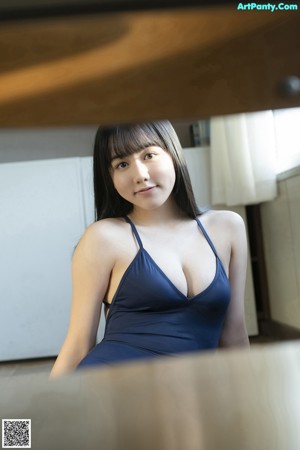 A woman in a white bikini sitting on a bench.