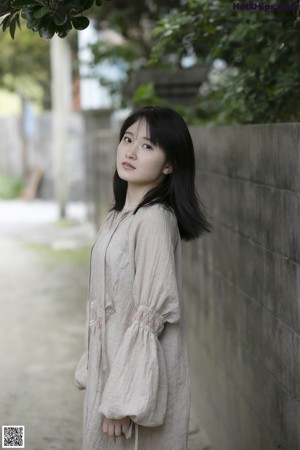 A woman in a white shirt and gray skirt posing for a picture.