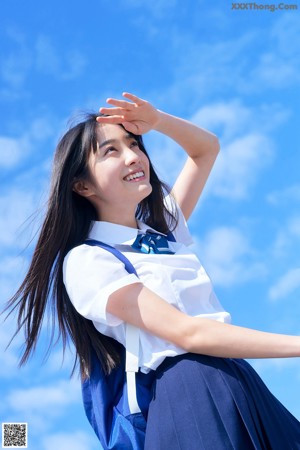 A woman in a gray shirt and pink shorts posing for a picture.