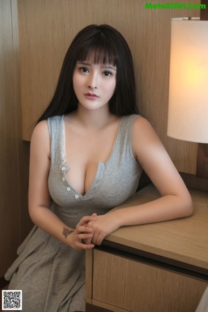 A woman in a gray dress posing for a picture.