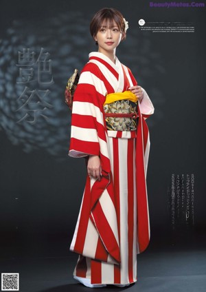 A woman in a red and white kimono posing for the camera.