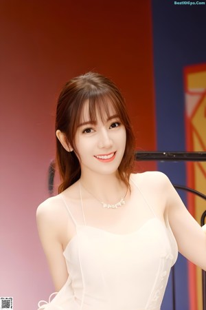 A woman in a pink dress posing for a picture.