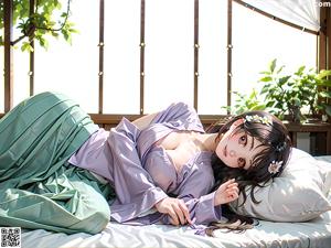 A woman in a kimono sitting on a bed.