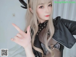 a woman in a black catsuit is posing for the camera