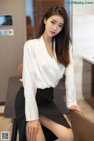 A woman sitting at a table with her feet up on the table.