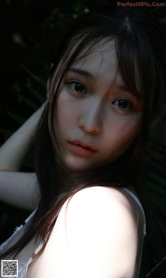 A woman with long black hair is posing for a picture.