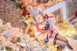 A woman sitting on a chair in front of a Christmas tree.