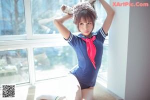 A woman in a blue dress and bunny ears sitting on a window sill.