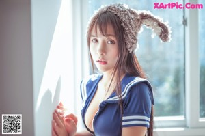 A woman in a bunny costume sitting on a window sill.